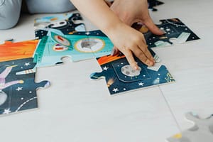 Child completing jigsaw puzzle. - CurioBuddy Putting the pieces together in Jigsaws challenges kids (and grown-ups too!) to develop and refine their problem-solving abilities in a fun and engaging way with CurioBuddy