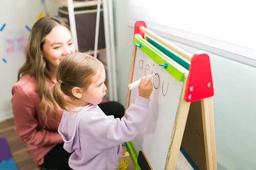Kid Writing on Whiteboard - CurioBuddy Writing helps develop various skillset together in kids and provides unique perspective along with reading.