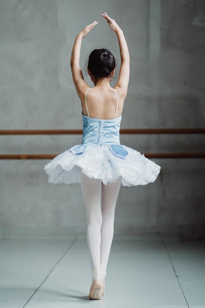 Dance The World - CurioBuddy Ballet dancer on tiptoes with hands up. CurioBuddy promotes all form of creativity. Join #CreateWithCB today.