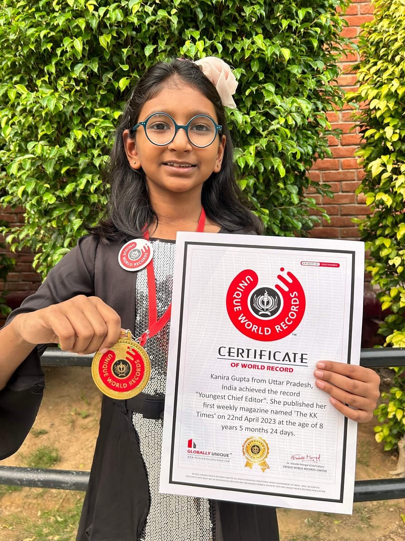 IMG_KGaward_curiobuddy - CurioBuddy Kanira Gupta, the world's youngest chief editor of a magazine - The KK Times, smiling and showing her certificate, medal and badge after breaking the record.